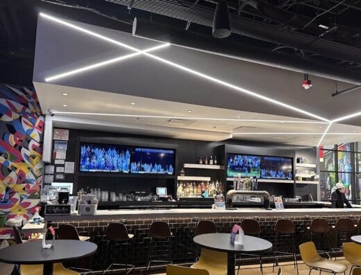 Bar with cafe seating and TVs at Five Iron Golf in Chicago, IL